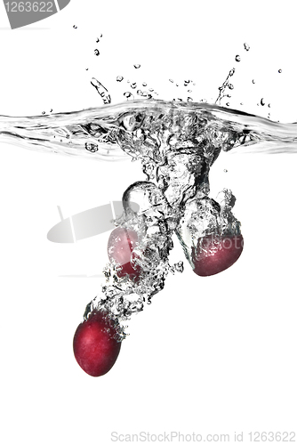 Image of plum dropped into water with bubbles isolated on white