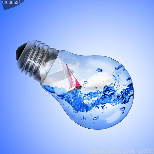 Image of Energy concept. Light bulb with water and yacht inside isolated 