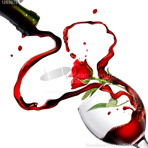Image of Heart from pouring red wine in goblet with red rose isolated on 