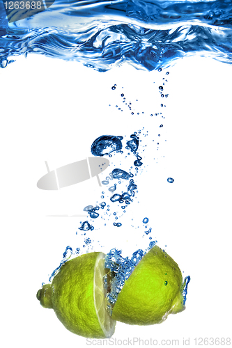 Image of Fresh lime dropped into water with bubbles isolated on white