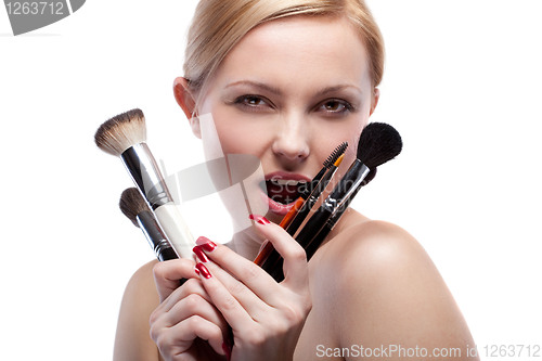 Image of Young smiling woman with make up brushes isolated on white