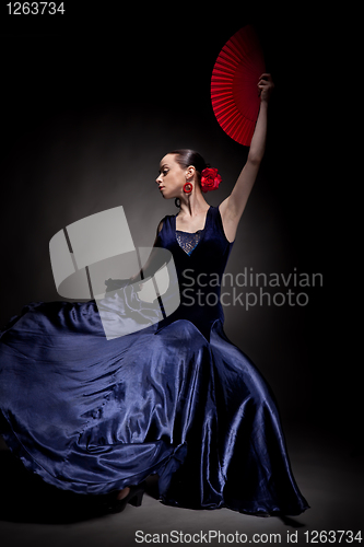 Image of young woman dancing flameno on black