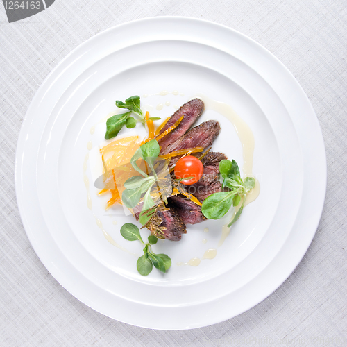 Image of fried meat with vegetables on the plate isolated on white
