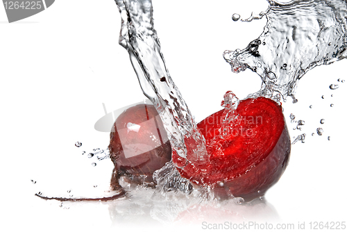 Image of red beet with water splash isolated on white