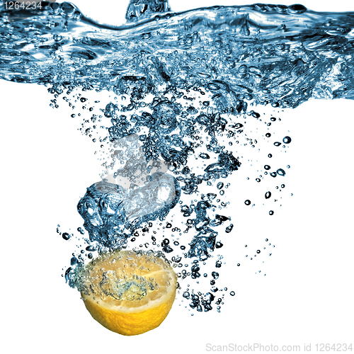 Image of Fresh lemon dropped into water with bubbles isolated on white