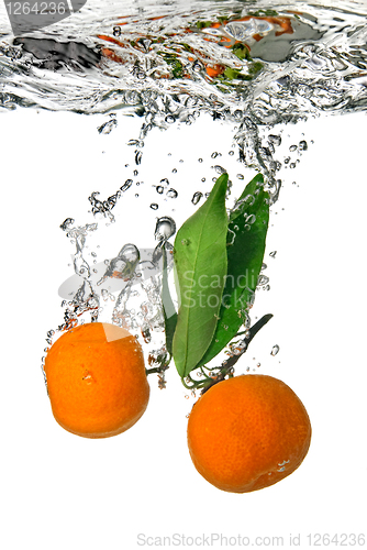 Image of tangerine dropped into water with bubbles on white