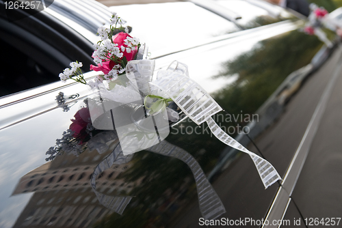 Image of Door of black wedding car with flower and ribbon