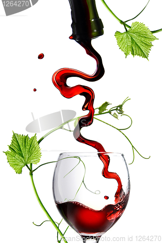 Image of Pouring red wine in glass with rod isolated on white
