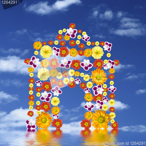 Image of arc of triumph from flowers with reflection against blue sky