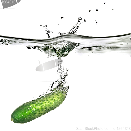 Image of green cucumber dropped into water isolated on white