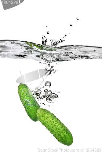 Image of green cucumber dropped into water isolated on white