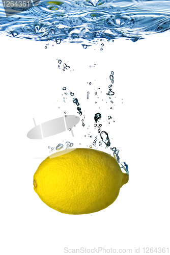 Image of Fresh lemon dropped into water with bubbles isolated on white