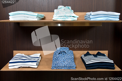 Image of wooden store shelf with color clothes