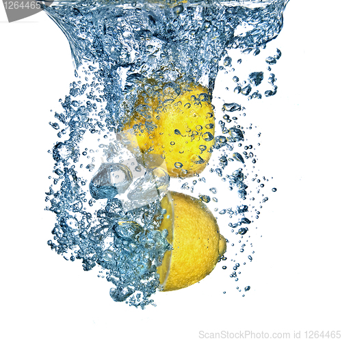 Image of Fresh lemon dropped into water with bubbles isolated on white