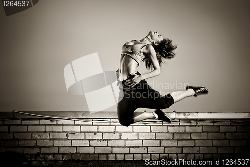 Image of black and white photo of girl jumping on the roof