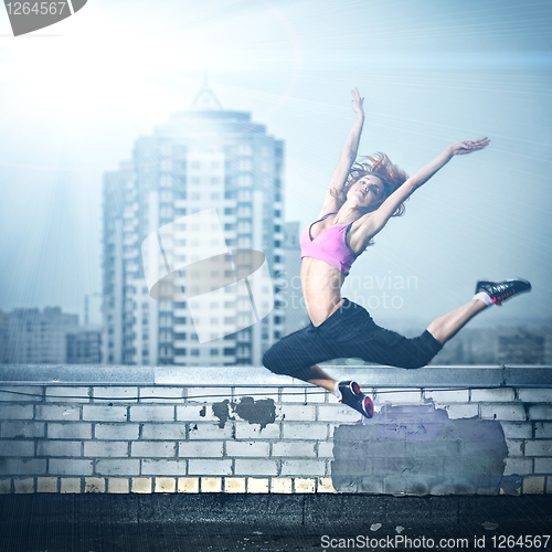 Image of girl posing on the roof against city background