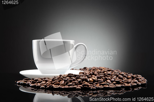 Image of white cup with coffee beans on black