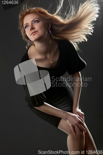 Image of Portrait of attractive young smiling woman on black