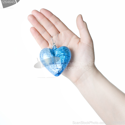 Image of arm holding blue christmas ball in shape of heart isolated on wh