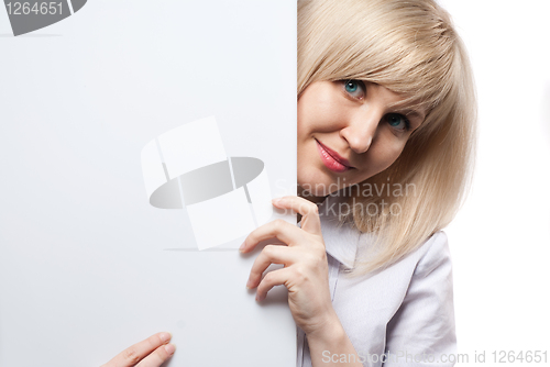 Image of Attractive smiling woman holding white empty paper isolated on w