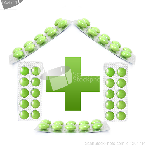 Image of House from packs of green tablets and cross isolated on white