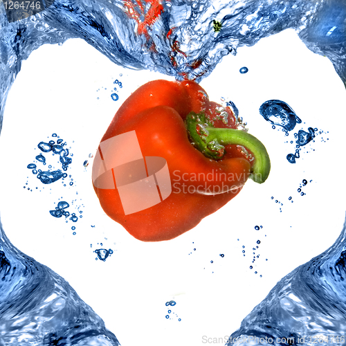 Image of Red pepper with shape of heart from blue water isolated on white