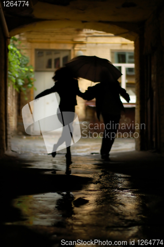 Image of silhouette of couple with umbrella running from rain