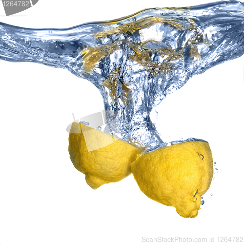 Image of Fresh lemon dropped into water with bubbles isolated on white