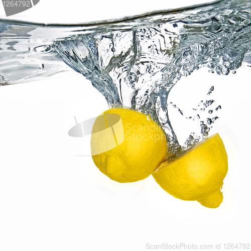 Image of Fresh lemon dropped into water with bubbles isolated on white