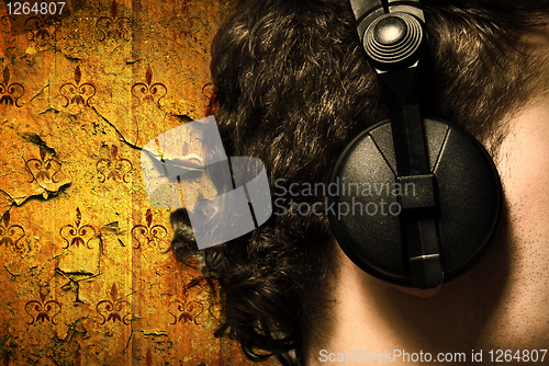 Image of urban style photo of the man in headphones listening to musiñ
