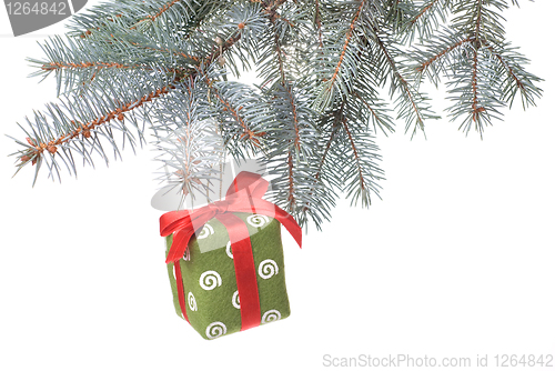 Image of Christmas gift on fir tree branch isolated on white