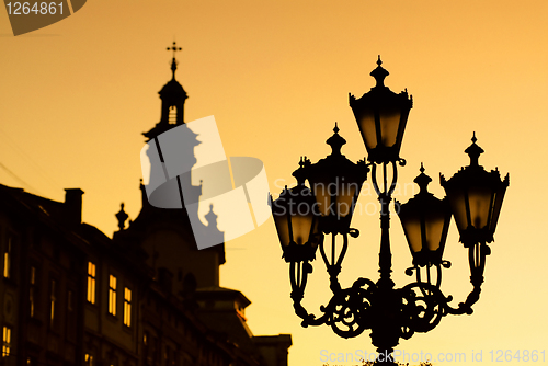 Image of silhouettes of city lantern on the sunset