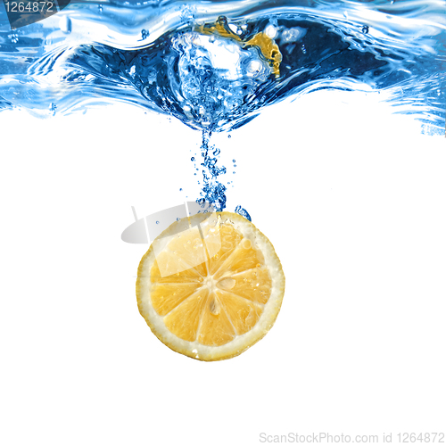 Image of Fresh lemon dropped into water with bubbles isolated on white