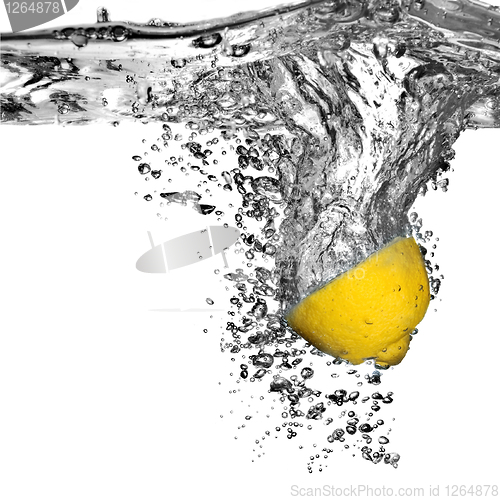 Image of Fresh lemon dropped into water with bubbles isolated on white