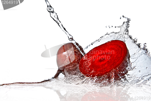 Image of red beet with water splash isolated on white