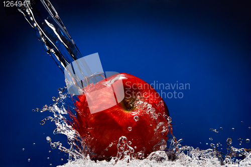 Image of Green apple with water splash on blue background