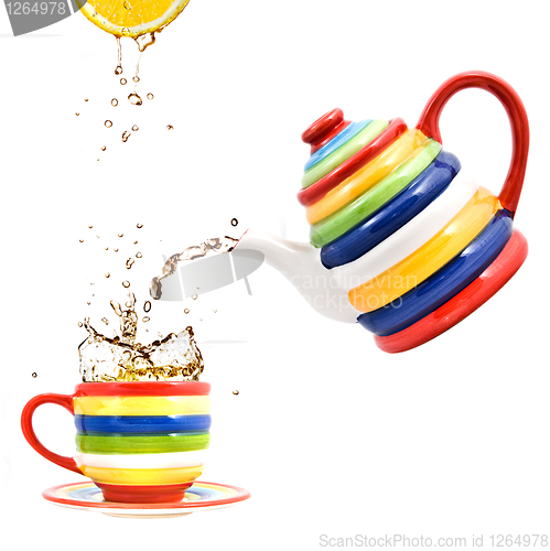 Image of color teapot with cup and lemon isolated on white