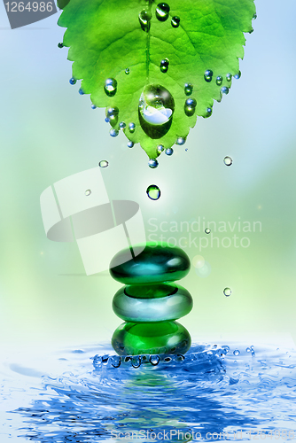 Image of balancing spa shiny stones in water splash with leaf and drops