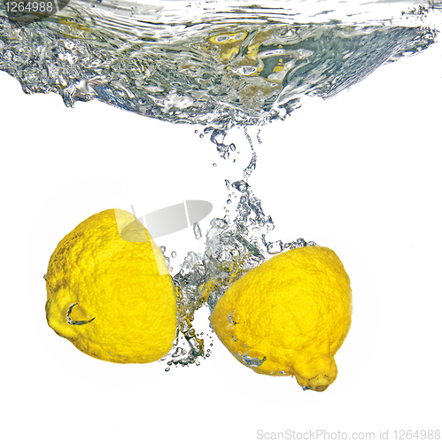 Image of Fresh lemon dropped into water with bubbles isolated on white