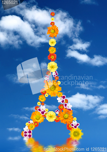 Image of eiffel tower from flowers with reflection against blue sky