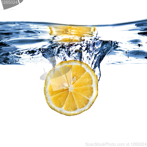 Image of Fresh lemon dropped into water with bubbles isolated on white