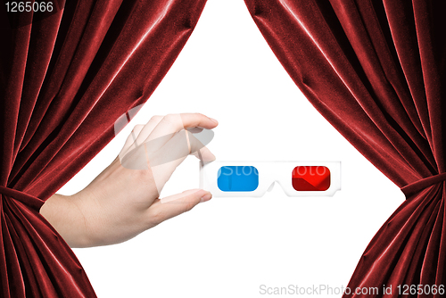 Image of hand holding stereo glasses on white background with curtains