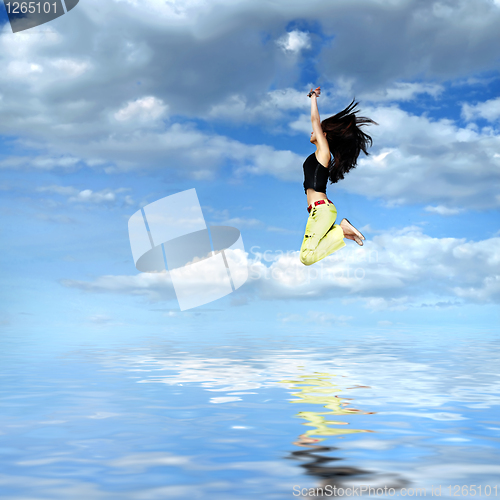 Image of girl jumping against blue sky with water reflection