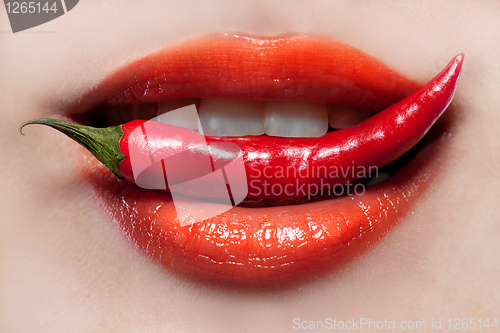 Image of Woman lips and chili pepper
