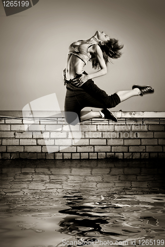 Image of black and white photo of girl jumping on the roof in the water