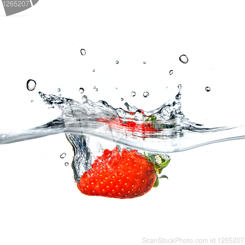 Image of Fresh strawberry dropped into blue water with splash isolated on