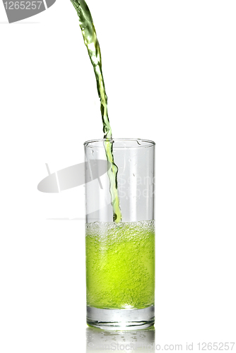 Image of green juice pouring into glass isolated on white