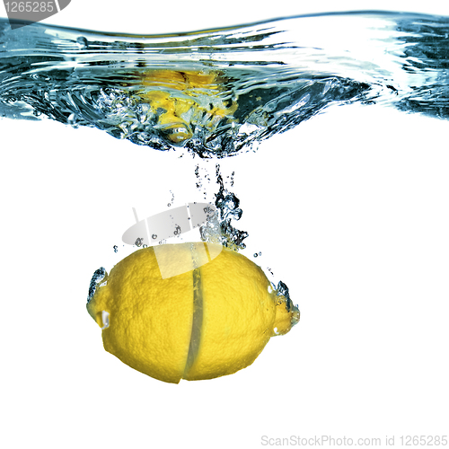Image of Fresh lemon dropped into water with bubbles isolated on white