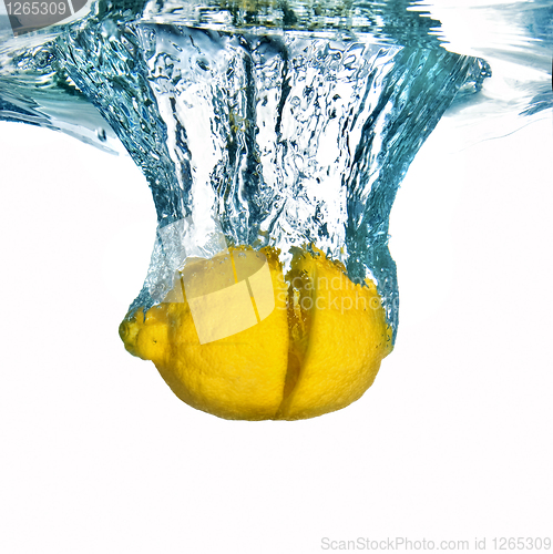 Image of Fresh lemon dropped into water with bubbles isolated on white