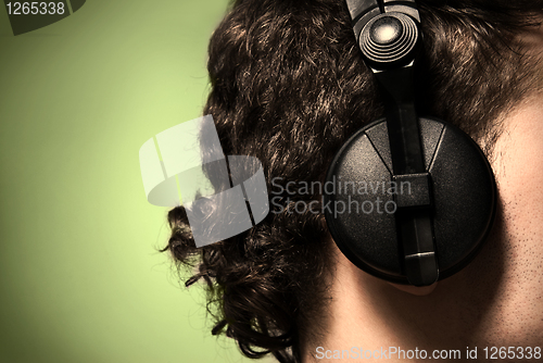 Image of urban style photo of the man in headphones listening to musiñ